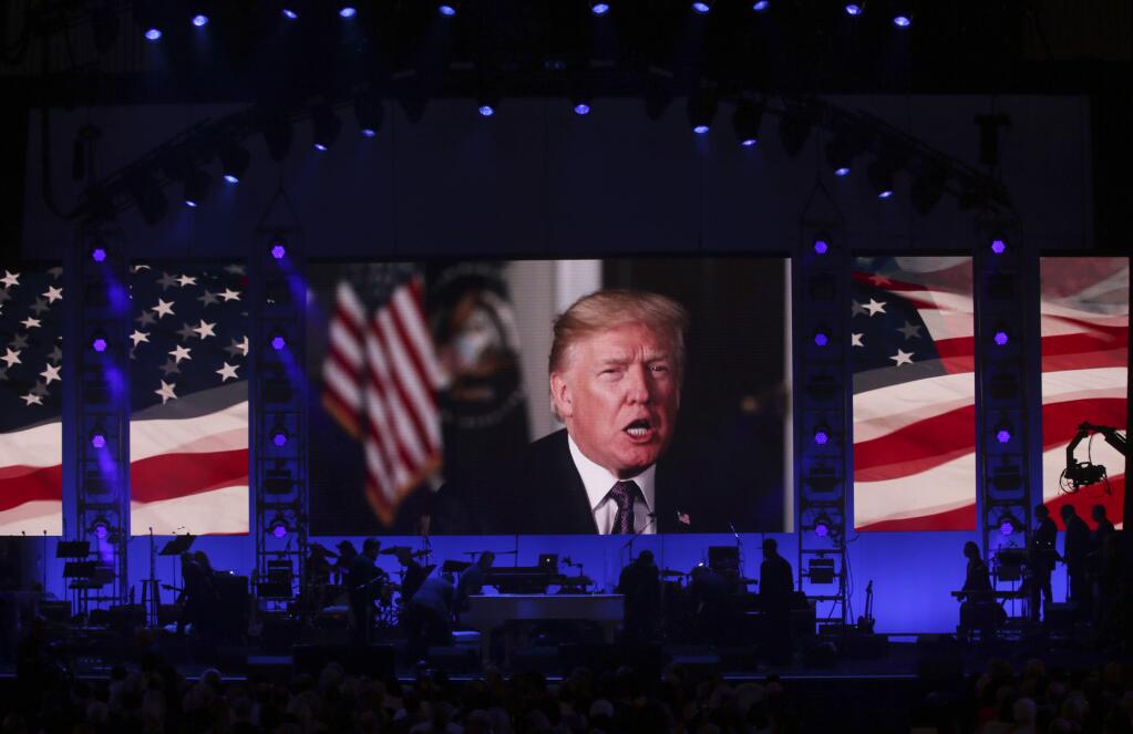A video message from President Donald Trump is played on the stage during a hurricanes relief concert in College Station, Texas, Saturday, Oct. 21, 2017. All five living former U.S. presidents, Jimmy Carter, George H.W. Bush, Bill Clinton, George W. Bush and Barack Obama, joined to support a Texas concert raising money for relief efforts from Hurricane Harvey, Irma and Maria's devastation in Texas, Florida, Puerto Rico and the U.S. Virgin Islands. (AP Photo/LM Otero)