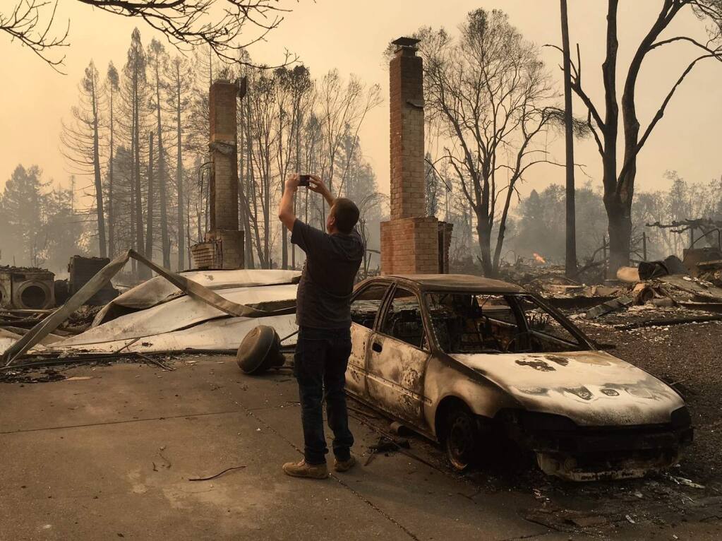 A man takes a photo of the devastation in the Coffey Park neighborhood of Santa Rosa on Monday, Oct. 9, 2017. (KENT PORTER/ The Press Democrat)