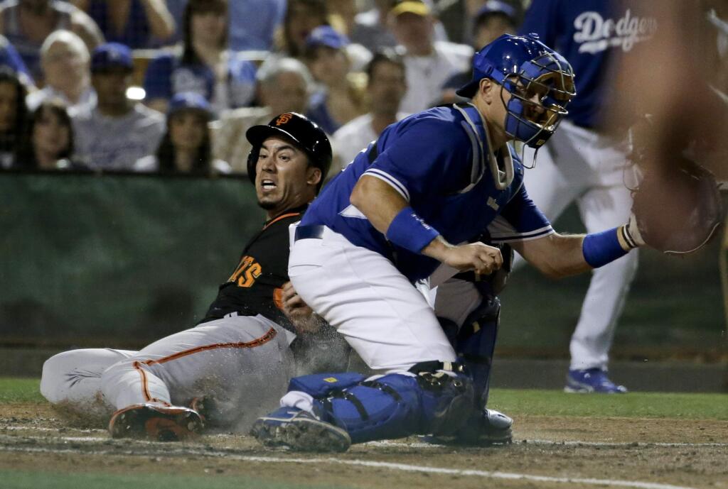 San Francisco Giants' Travis Ishikawa scores past Los Angeles Dodgers catcher A.J. Ellis on a triple by Gregor Blanco during the fourth inning of a spring training game in Glendale, Ariz., on Friday, March 27, 2015. (AP Photo/Chris Carlson)