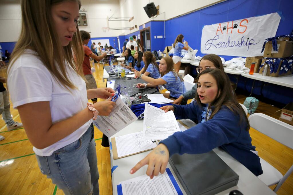Angelina Leal, 16, right, helps to direct Emma Miloglav, 17, during registration at Analy High School in Sebastopol on Wednesday, August 7, 2019. (BETH SCHLANKER/ The Press Democrat)