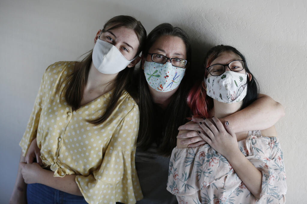 Lynn Calza with her children, Leilani Pickett, 17, left, and Nila Pickett, 14, at their home in Petaluma on Tuesday, Jan. 19, 2021. (Beth Schlanker / The Press Democrat)