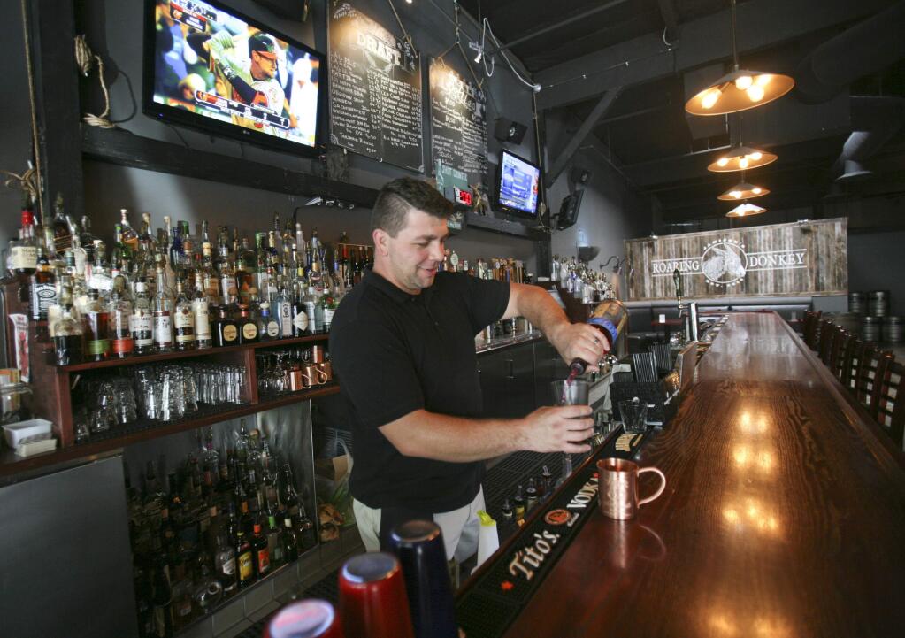 Justin Ricketts mixes a Hibiscus Bliss, made up of hibiscus infused vodka, lime, and cucumber, at Jamison's Roaring Donkey on Kentucky Street in downtown Petaluma on Wednesday October 15, 2014. (SCOTT MANCHESTER/ARGUS-COURIER STAFF)
