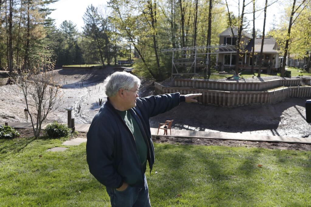 Home owner Glenn Hart describes where the water level was next to Wixom Lake, in Edenville Township, Mich., Thursday, May 21, 2020, before the Edenville Dam failed and flood waters rushed south. (AP Photo/Carlos Osorio)