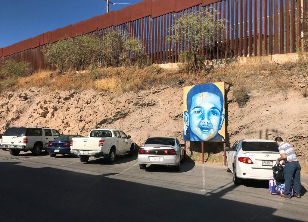 In this Dec. 4, 2017 photo, a portrait of 16-year-old Mexican youth Jose Antonio Elena Rodriguez, who was shot and killed in Nogales, Sonora, Mexico, is displayed on the street where he was killed that runs parallel with the U.S. border. A U.S. border patrol agent is going on trial for second-degree murder in U.S. District Court in Tucson on Tuesday, March 20, 2018, in a rare Justice Department prosecution of a fatal cross-border Mexico shooting. Lonnie Swartz is charged with firing multiple shots from the Arizona side of the border into Nogales, Mexico more than five years ago and killing Rodriguez. (AP Photo/Anita Snow)