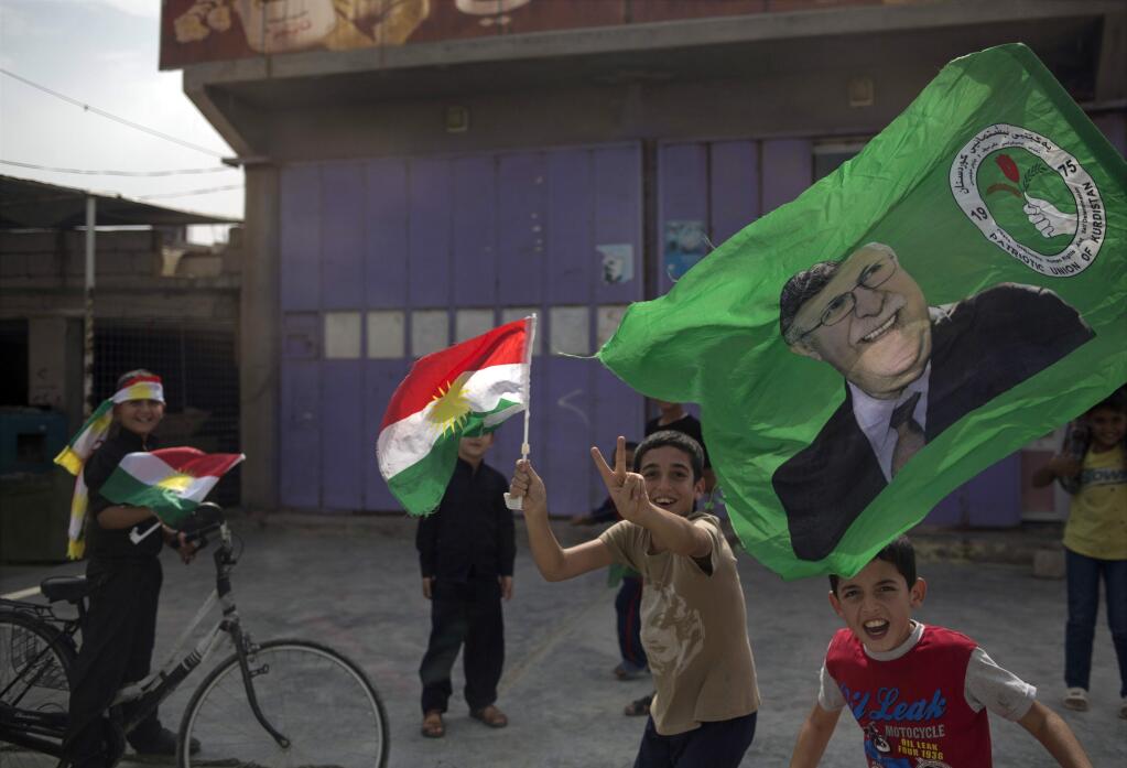 Children holding Kurdish flags run on the streets of the disputed city of Kirkuk, Monday Sept. 25, 2017. Millions are expected to vote on Monday in Iraq's Kurdish-run provinces and disputed territories as Iraqi Kurds cast ballots in support for independence from Baghdad in a historic but non-binding vote. (AP Photo/Bram Janssen)