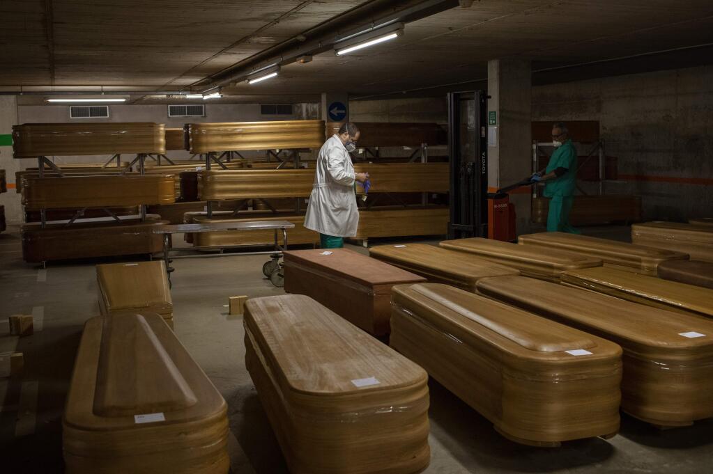 Coffins with the bodies of victims of coronavirus are stored waiting for burial or cremation at the Collserola morgue in Barcelona, Spain, Thursday, April 2, 2020. The new coronavirus causes mild or moderate symptoms for most people, but for some, especially older adults and people with existing health problems, it can cause more severe illness or death. (AP Photo/Emilio Morenatti)
