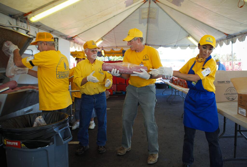 Petaluma, CA. Monday, October 23, 2017._Volunteers from Disaster Relief California, which partnered with the Red Cross, (L-R) Gary Burton of Ojai; Marvin Rackley of Nevada City; George Ibert Hall of Rancho Cucamonga; and Shirley Moucheron of Lake Forest, used an assembly line method to prepare meals at the Red Cross tent in Petaluma. The meals were then transported to shelters for evacuees and those displaced by the wildfires in the North Bay. (CRISSY PASCUAL/ARGUS-COURIER STAFF)