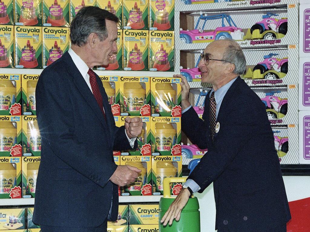 FILE- In this Jan. 7, 1992, file photo, President George H. Bush, left, listens to Toys R Us Chairman Charles Lazarus, right, as he visits the toy chain's second store to open in Japan. Lazarus, the World War II veteran who founded Toy R Us, has died at age 94. Toy R Us confirmed Lazarus' death in a statement Thursday, March 22, 2018. (AP Photo, File)