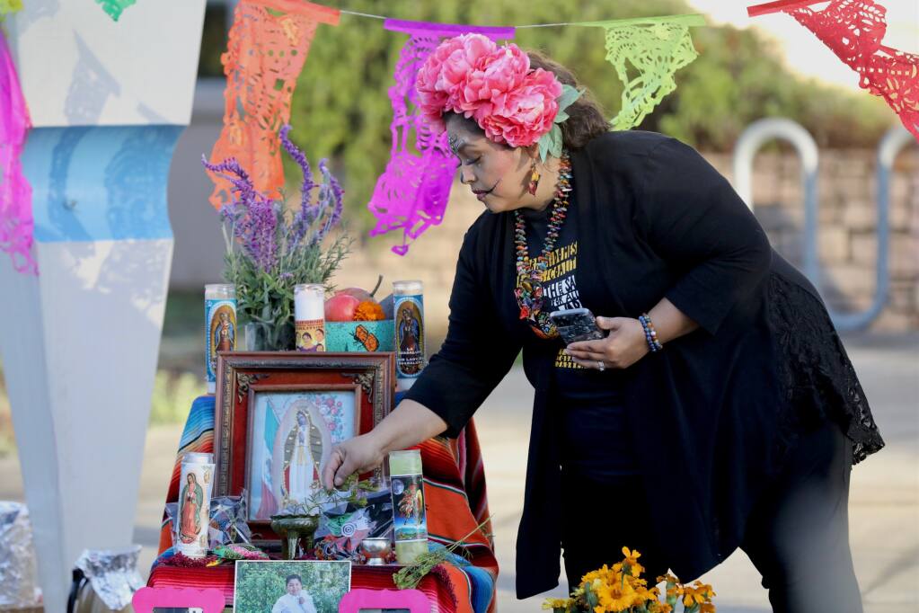 Socorro Diaz lights sage during a Day of Dead event in Santa Rosa on Tuesday, Nov. 2, 2021. (Beth Schlanker / The Press Democrat)