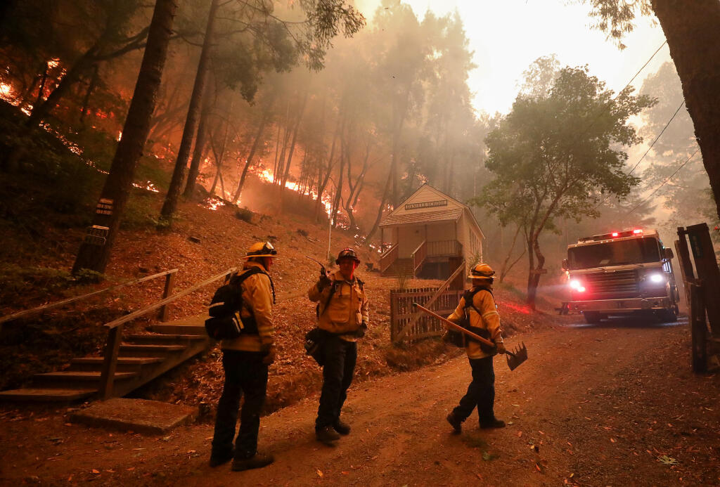 Sonoma Valley firefighters plan their effort to protect the Daniels School building and watch their exit route along Mill Creek Road, west of Healdsburg, on Wednesday, Aug.19, 2020.  (Christopher Chung / The Press Democrat)