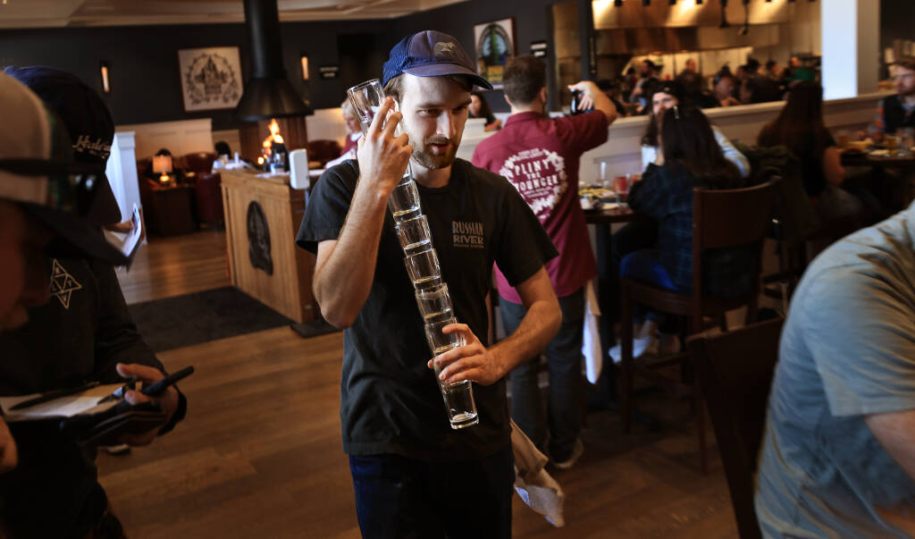 James Johnson of the Russian River Brewing Company has his hands full with empty Pliny the Younger serving glasses, Tuesday, April 5, 2022, in Windsor. (Kent Porter / The Press Democrat file)
