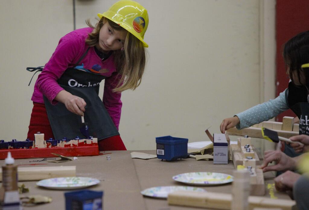 Maya Moran, 8, paints the menorah she just made at the workshop. (CRISSY PASCUAL/ARGUS-COURIER STAFF)