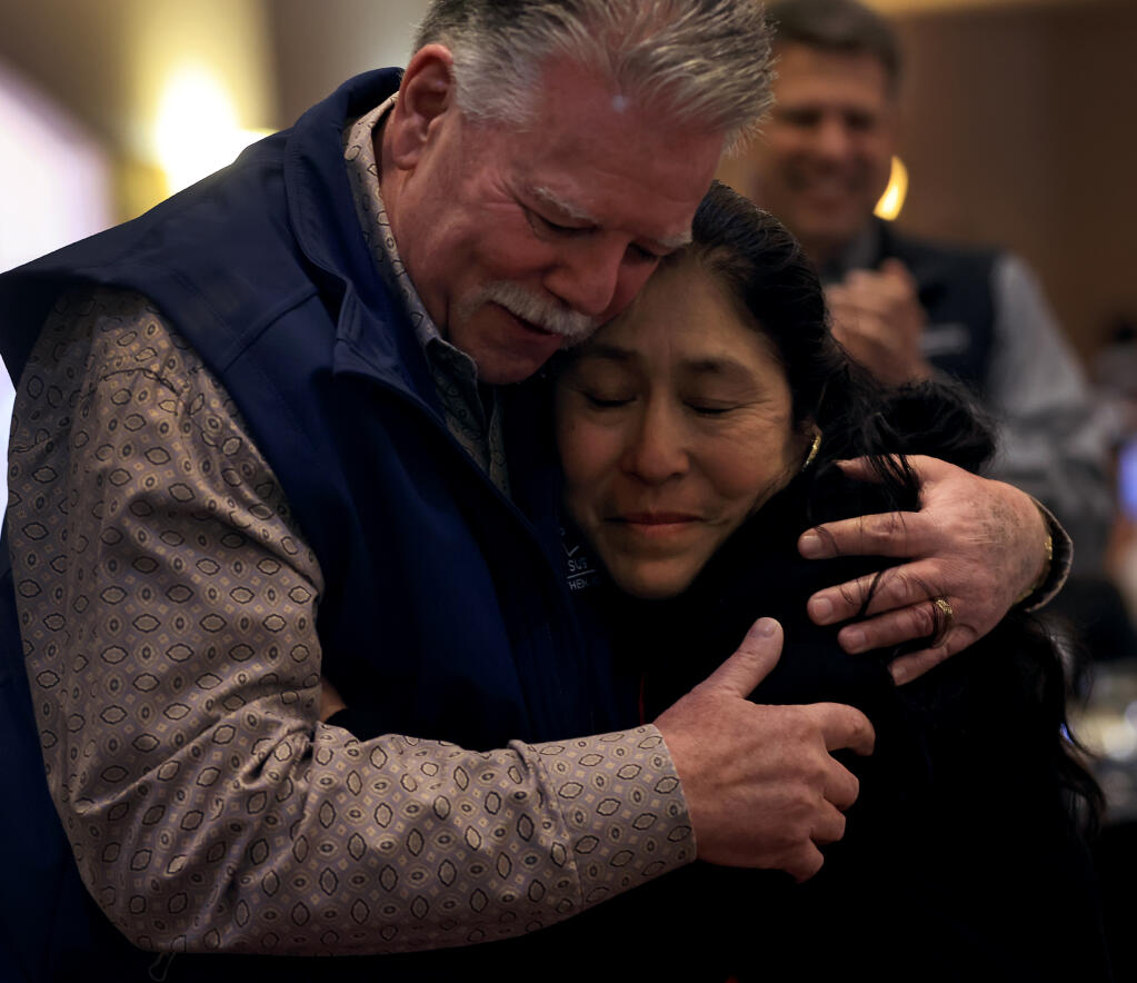 Yolanda Cruz, the vineyard forewoman at Redwood Empire Vineyard Management is embraced by the company’s owner, Kevin Barr, after Cruz was named the Vineyard Employee of the Year by the Fundación de la Voz de los Viñedos (Voice of the Vineyards Foundation) in Windsor, Saturday, Feb. 10, 2024.  (Kent Porter / The Press Democrat)