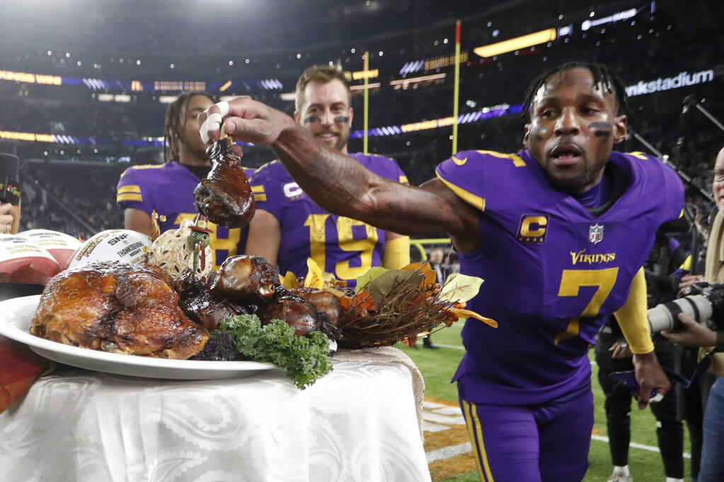 Minnesota Vikings cornerback Patrick Peterson grabs a turkey leg off a plate before being interviewed after Thursday’s win against the New England Patriots. (Bruce Kluckhohn / ASSOCIATED PRESS)