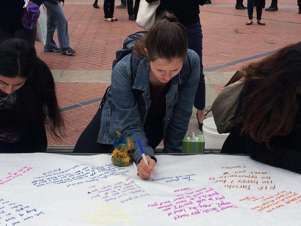 People sign a condolence page on the steps of Sproul Plaza at University of California Berkeley on Tuesday, July 5, 2016 in Berkeley, Calif. The university held a vigil for Tarishi Jain, a student who was among the 20 hostages killed by militants in an attack on a restaurant in Bangladesh. Jain was in the capital of Dhaka for a summer internship that began last month. (AP Photo/Terry Chea)