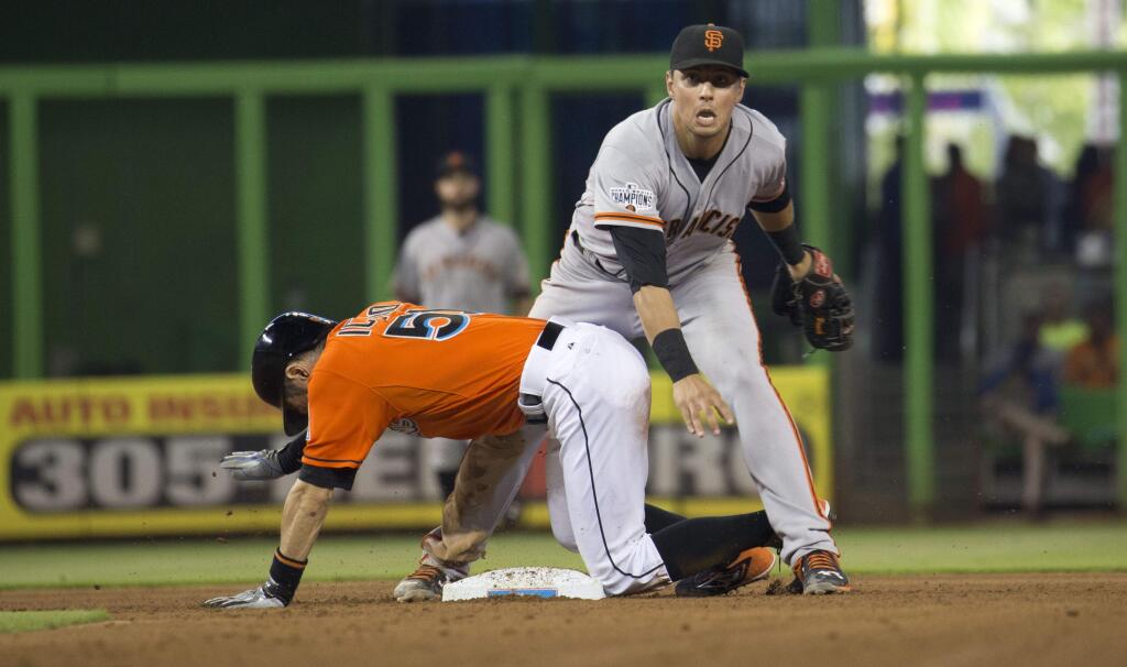 San Francisco Giants second baseman Joe Panik watches his throw to first to complete a double play after tagging out Miami Marlins' Ichiro Suzuki, bottom, during the fourth inning of a baseball game in Miami, Thursday, July 2, 2015. (AP Photo/J Pat Carter)