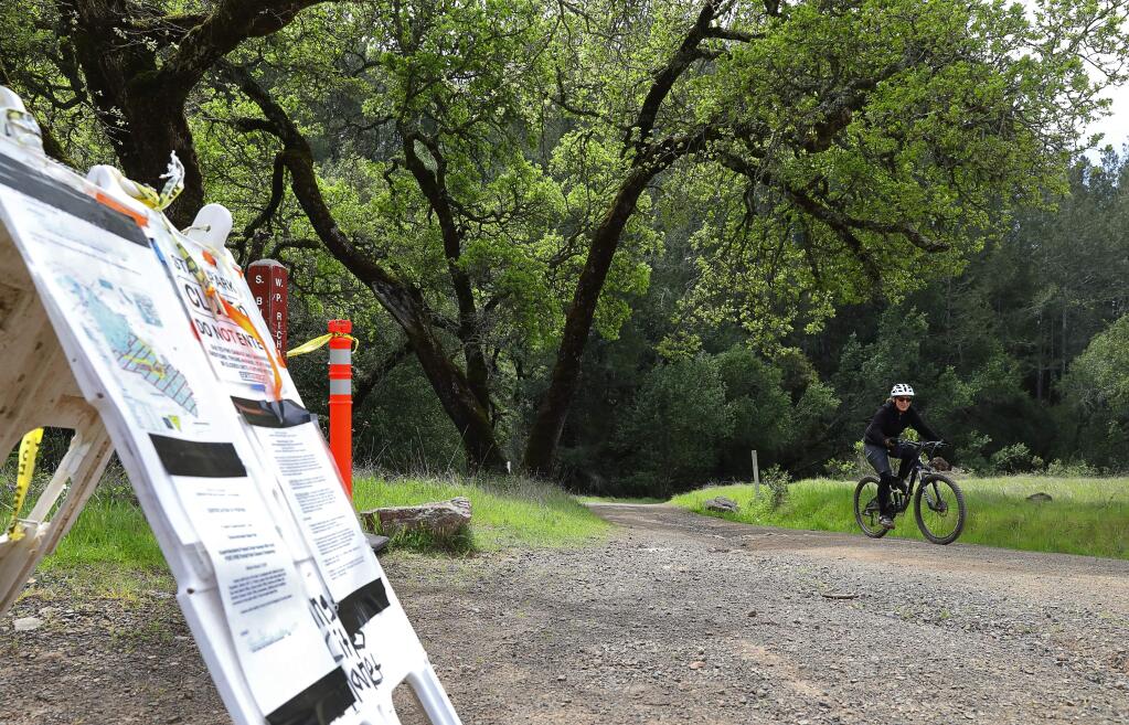 Susan Jablonski rides her bike up the Warren Richardson Trail in Trione-Annadel State Park, past the barricade closing off the South Burma Trail, in Santa Rosa on Wednesday, April 4, 2018. (Christopher Chung/ The Press Democrat)