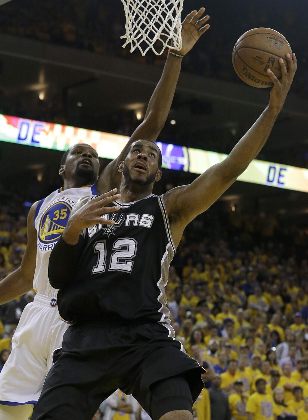 San Antonio Spurs forward LaMarcus Aldridge (12) shoots against Golden State Warriors forward Kevin Durant during the second half of Game 1 of the NBA basketball Western Conference finals in Oakland, Calif., Sunday, May 14, 2017. The Warriors won 113-111. (AP Photo/Jeff Chiu)