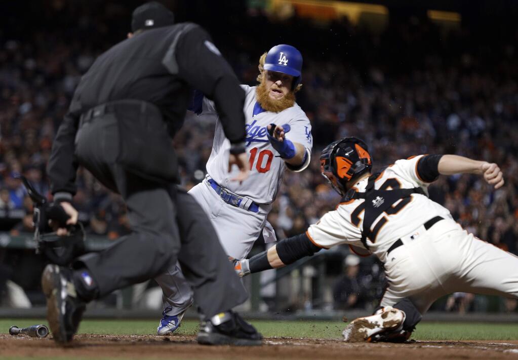 Los Angeles Dodgers' Justin Turner (10) is tagged out at home plate by San Francisco Giants catcher Buster Posey, right, during the fourth inning of a baseball game Tuesday, May 16, 2017, in San Francisco. Turner attempted to score on a single by Austin Barnes. (AP Photo/Ben Margot)