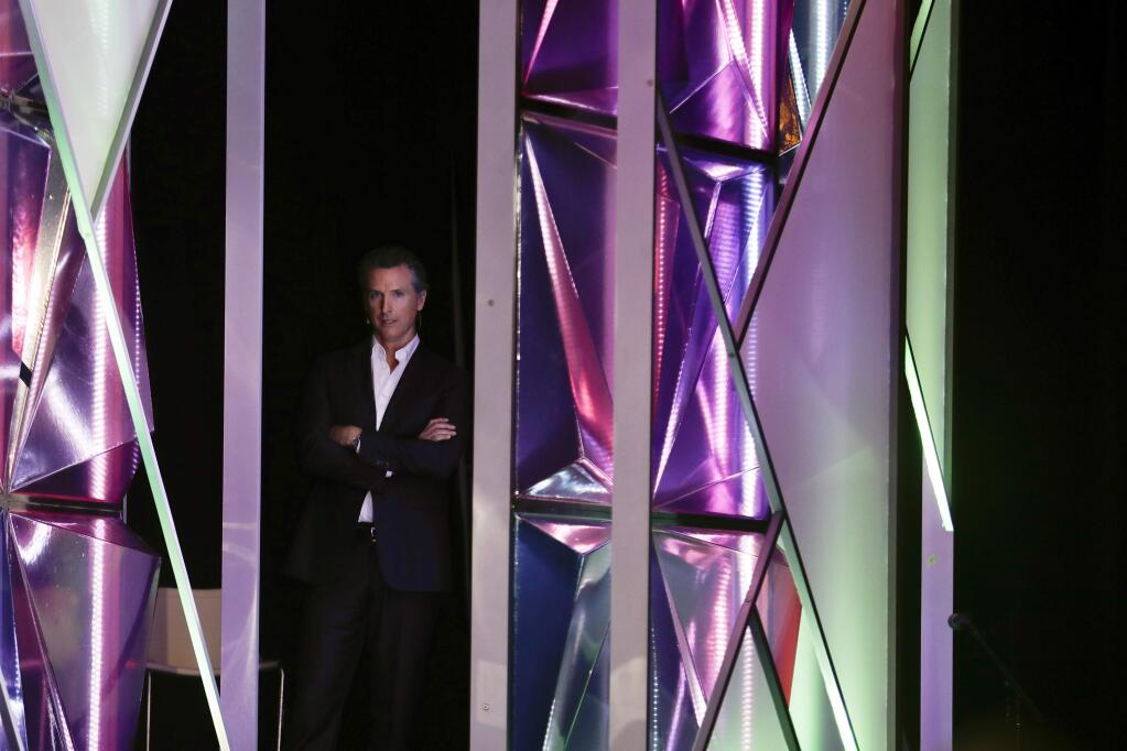 California Gov. Gavin Newsom looks on from the side of the stage before announcing a new X Prize aimed at helping combat wildfires, during the Near Future conference, Friday, May 10, 2019, in San Diego. Newsom announced the new prize Friday alongside X Prize founder and chairman Peter Diamandis, saying the prize will focus on new ways to detect wildfires before they happen and reduce their spread if they occur. (AP Photo/Gregory Bull)
