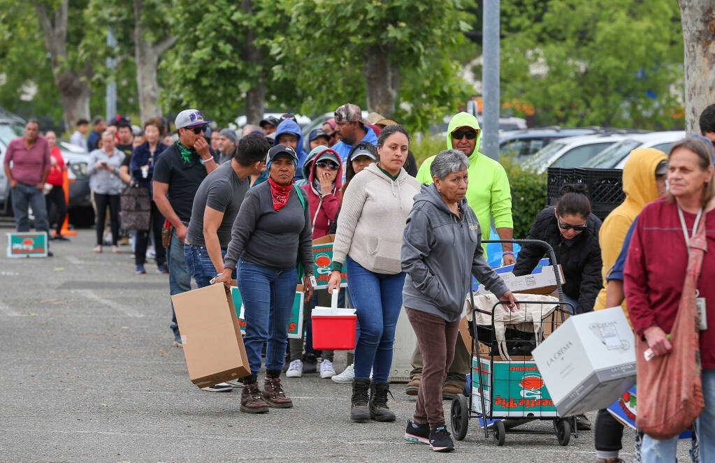 Clients line up for food during a Redwood Empire Food Bank distribution event at the Santa Rosa Veterans Memorial Building in Santa Rosa, Thursday, May 25, 2023.  (Christopher Chung / The Press Democrat)