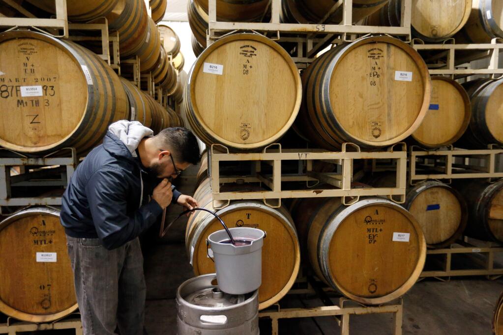 Esterlina Vineyards and Winery cellarmaster Beto Baltazar siphons a sample of a 2012 Cabernet Sauvignon from a barrel into a smaller keg, in the winery's barrel room in Healdsburg on Wednesday, Feb. 17, 2016. Esterlina Vineyards is one of the few African-American family-owned wineries in Sonoma County. (Alvin Jornada / The Press Democrat)