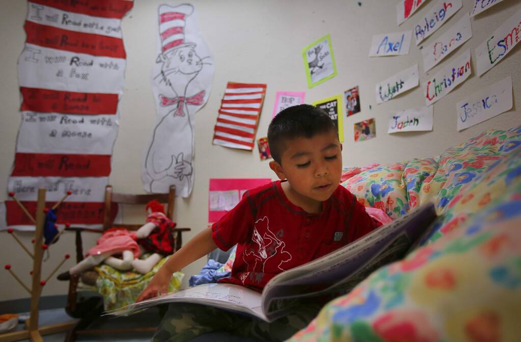 Eric Ortiz looks through a book at Willow Creek State Preschool in Santa Rosa, on Wednesday, March 30, 2016. (Christopher Chung/ The Press Democrat)