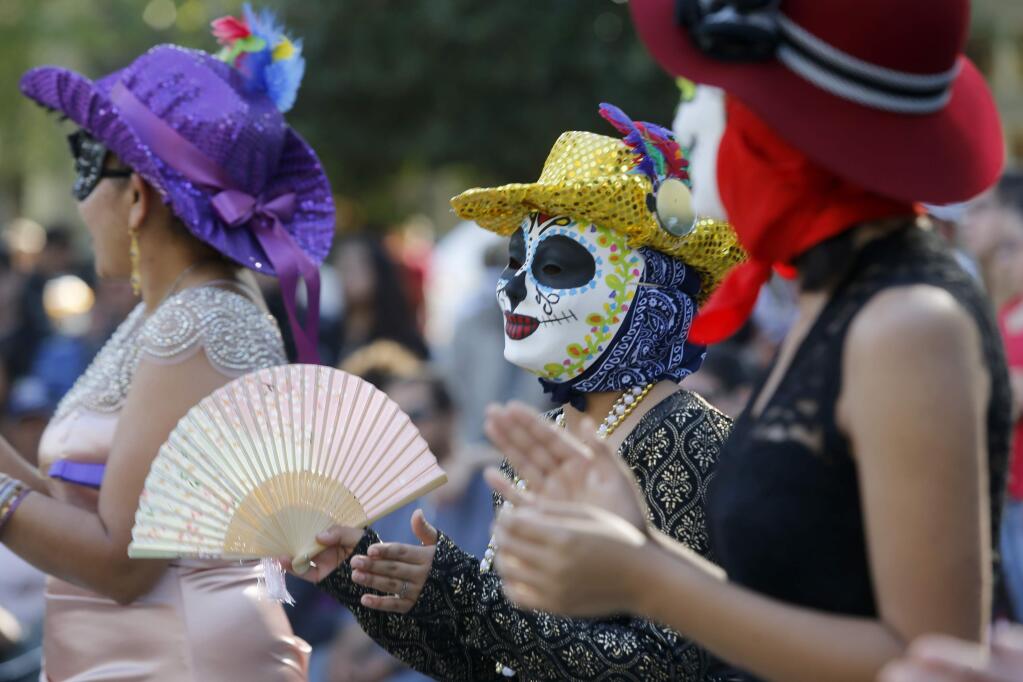 Dancers perform in front of a crowd during the Dia de los Muertos celebration at the Healdsburg Plaza on Sunday, October 29, 2017 in Healdsburg, California . (BETH SCHLANKER/The Press Democrat)