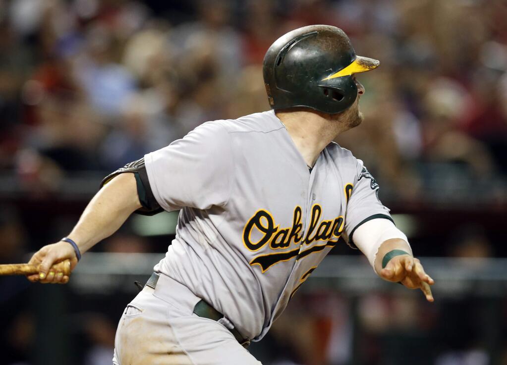 Oakland Athletics' Stephen Vogt hits an RBI single in the eighth inning during a game against the Arizona Diamondbacks, Saturday, Aug. 29, 2015, in Phoenix. (AP Photo/Rick Scuteri)