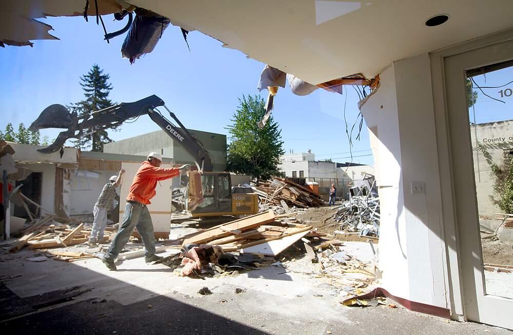 Workers clear debris from a county building being demolished in downtown Santa Rosa, Friday Sept, 5, 2012 to make way for a five-story housing and mixed-use building. (Kent Porter / Press Democrat) 2012