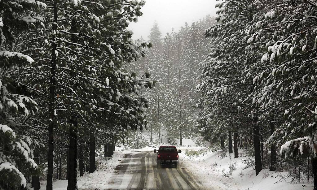 FILE - In this Tuesday, Jan. 3, 2017 file photo, a snow-covered Elk Mountain Road in the Mendocino National Forest above Upper Lake, Calif., greets a driver during a low-elevation snowfall. Water managers will once again manually measure California's snowpack, saying the state is on track for one of the wettest winters on record after five years of drought. The California Department of Water Resources will do the survey Wednesday, March 1, 2017, in the Sierra Nevada. (Kent Porter/The Press Democrat via AP, File)