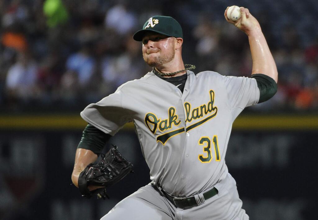 Oakland Athletics starting pitcher Jon Lester delivers to the Atlanta Braves during the first inning of a baseball game Sunday, Aug. 17, 2014, in Atlanta. (AP Photo/David Tulis)