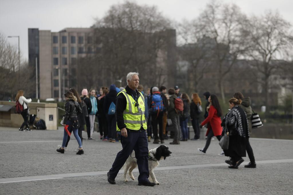 A security officer and his sniffer dog patrol next to the Tower of London, a popular tourist attraction in London, Thursday, March 23, 2017. On Wednesday a man went on a deadly rampage, first driving a car into pedestrians then stabbing a police officer to death before being fatally shot by police within Parliament's grounds in London. (AP Photo/Matt Dunham)