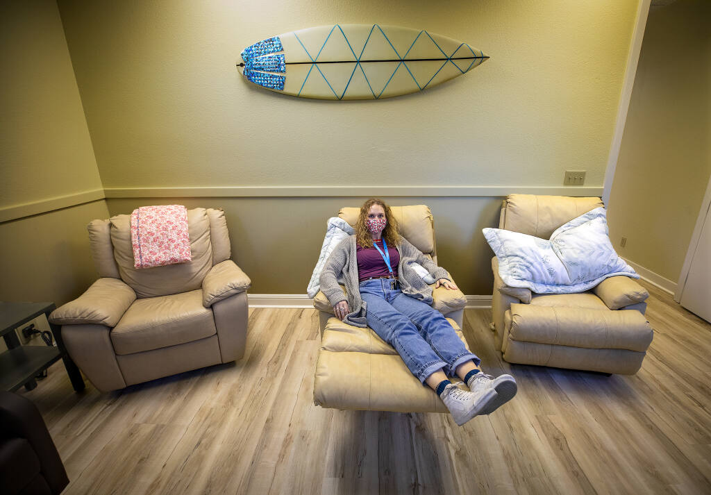 Outreach Coordinator Hannah Bunker sits in one of the lounge chairs where struggling women with children can seek quiet and peace at the new Living Room Life Center in Santa Rosa on Tuesday, March 22, 2022. (John Burgess/The Press Democrat)