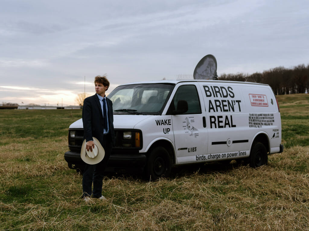 Peter McIndoe, the 23-year-old creator of the Birds Aren't Real movement, with his van in Fayetteville, Ark., on Tuesday, Dec. 7, 2021. In a post-truth world dominated by online conspiracy theories, young people have coalesced around the effort to thumb their nose at, fight and poke fun at misinformation. (Rana Young/The New York Times)