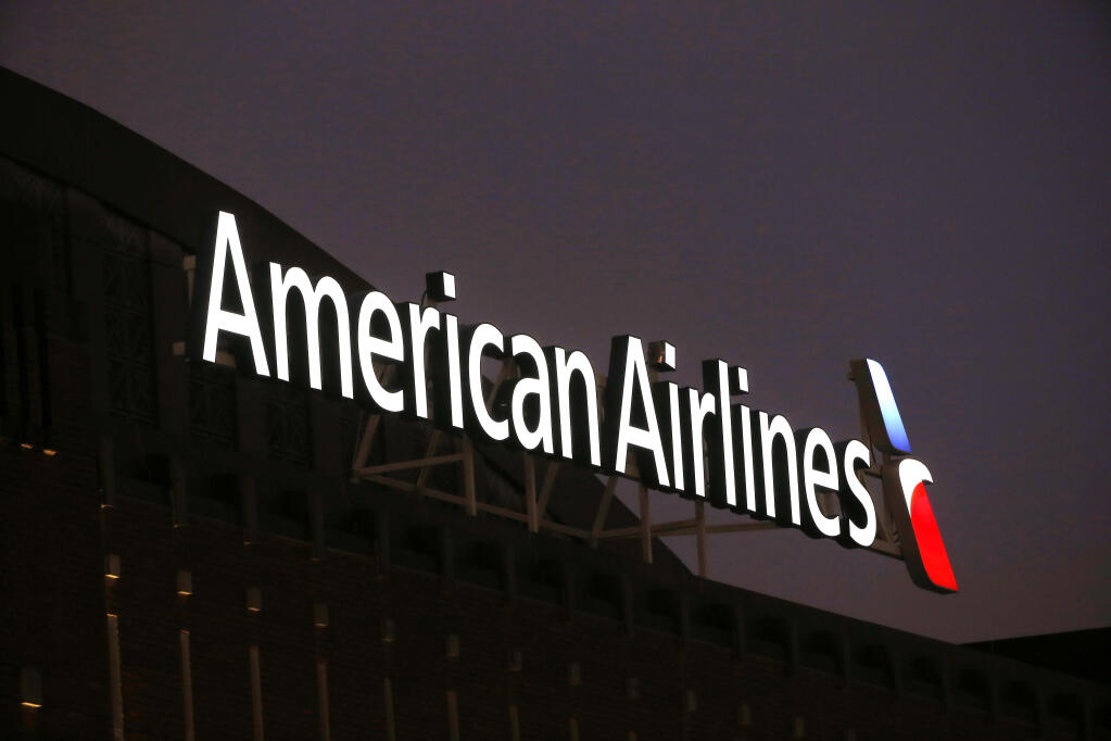 FILE - The American Airlines logo on top of the American Airlines Center in Dallas, Texas on Dec. 19, 2017.  Passengers and crew members restrained a passenger who was caught on video slugging a flight attendant on an American Airlines plane. The airline said Wednesday, Sept. 21, 2022,  that law enforcement met the plane when it landed in Los Angeles and took the man off the plane. (AP Photo/ Michael Ainsworth, file)