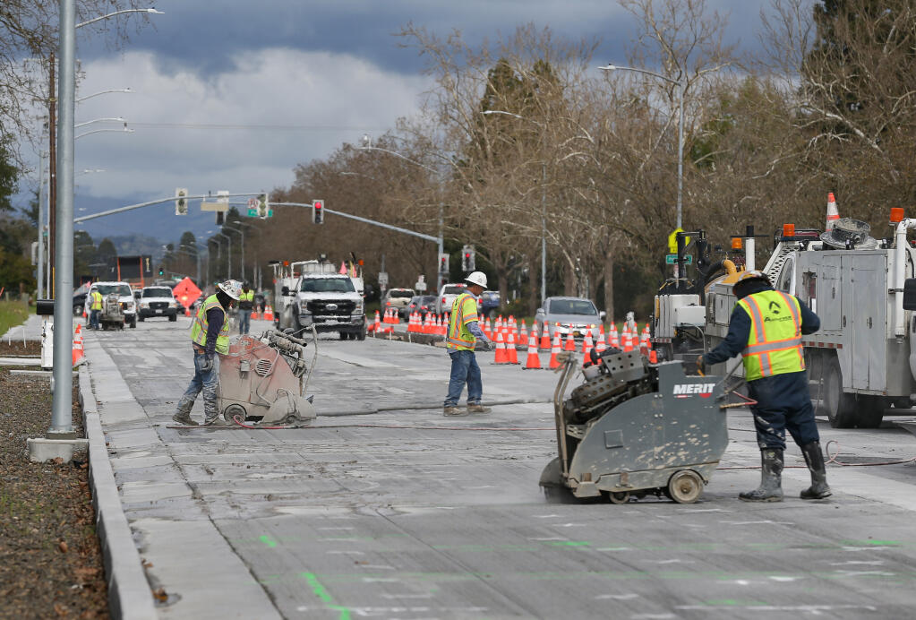 Workers cut into concrete along Fulton Road, south of Piner Road, in Santa Rosa, Wednesday, March 6, 2024. (Christopher Chung / The Press Democrat)