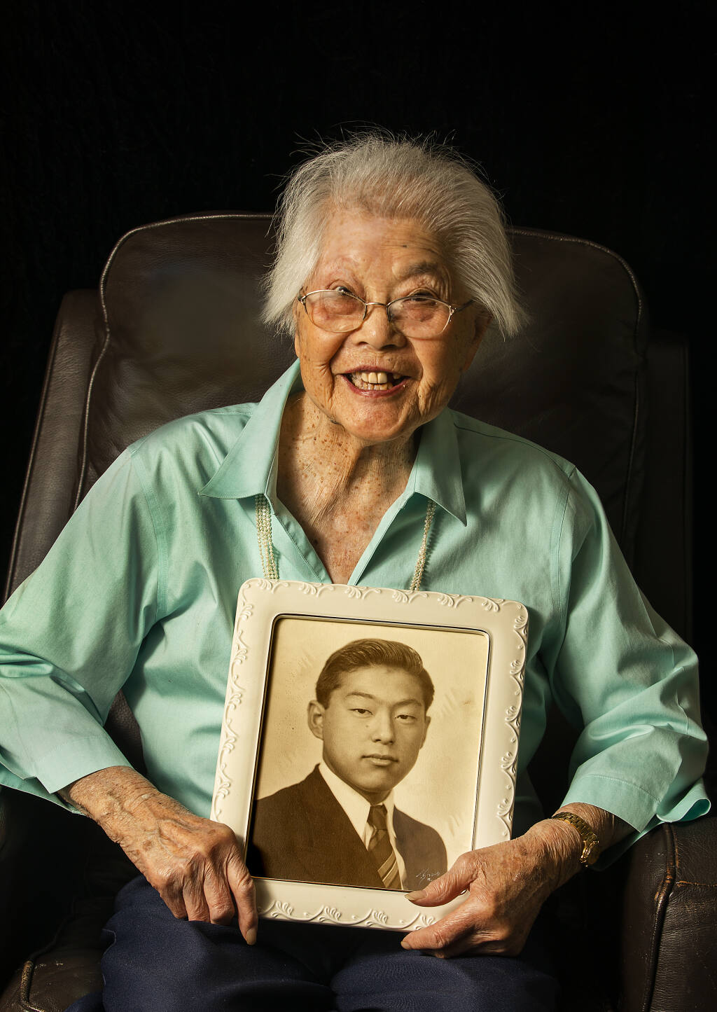 Anne Ohki, 97, was born along the Russian River and is one of 11 women interviewed in the new documentary “I Married the War.” She holds the high school graduation photo of her late husband Ed, who was part of famed 442nd Infantry Regiment during World War II. Photo taken in her Santa Rosa home on Jan. 24, 2022. (John Burgess/The Press Democrat)