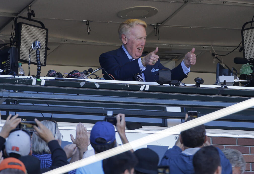 Los Angeles Dodgers announcer Vin Scully gestures to fans during the seventh inning stretch at a game against the Giants Saturday, Oct. 1, 2016. (Jeff Chiu / ASSOCIATED PRESS)