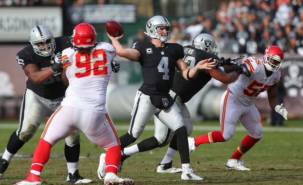 Oakland Raiders quarterback Derek Carr connects with wide receiver Michael Crabtree for a touchdown against the Kansas City Chiefs during their game in Oakland on Sunday, December 6, 2015. The Raiders lost to the Chiefs 34-20. (Christopher Chung / The Press Democrat)