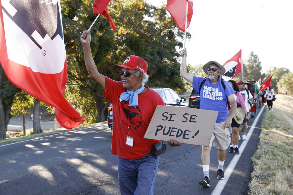 FILE - Asunción Ponce, left, marches with fellow members of the United Farm Workers in support of a bill that would allow farmworkers to vote by mail in union elections, near Walnut Grove, Calif., Wednesday, Aug. 24, 2022. Gov. Gavin Newsom, on Wednesday, Sept. 28, 2022, signed the measure. (Jessica Christian/San Francisco Chronicle via AP, File)