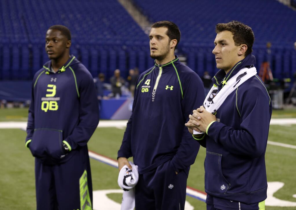 Texas A&M quarterback Johnny Manziel, right, Fresno State quarterback Derek Carr, center, and Louisville quarterback Teddy Bridgewater watch drills at the NFL football scouting combine in Indianapolis, Sunday, Feb. 23, 2014. (AP Photo/Michael Conroy)
