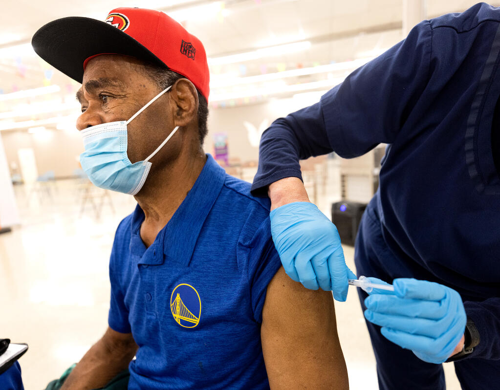Nosoni Tuitoga receives his flu shot Nov. 16 at the Roseland Community Clinic.    (John Burgess/Press Democrat)