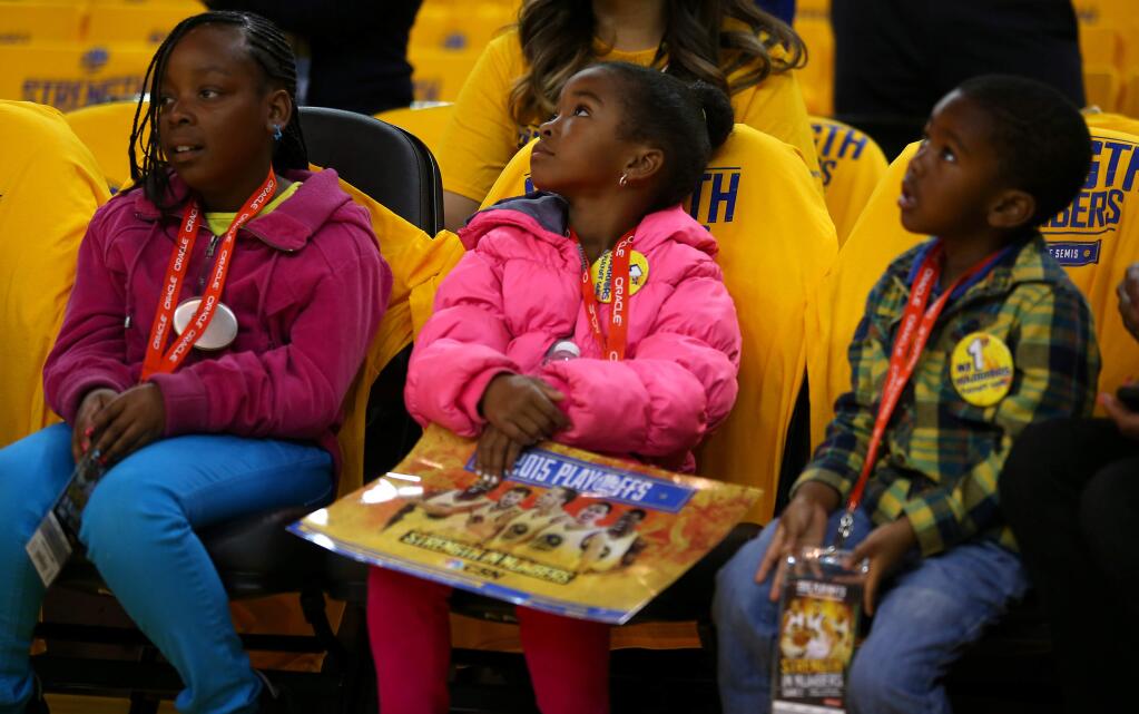 Young Golden State Warriors fans watch players warm up from the curtsied seats prior to Game 1 of the NBA Playoffs Western Conference Semifinals at Oracle Arena, in Oakland on Sunday, May 3, 2015. (Christopher Chung/ The Press Democrat)