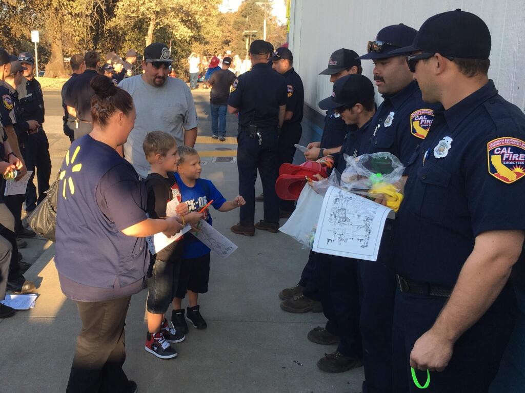 Lower Lake Elementary School students return to school, Tuesday, Aug. 23, 2016, a week after the Clayton fire. Teachers, Cal Fire and local fire officials were on hand to give out fire helmets, stickers and coloring books. (KENT PORTER/ PD)