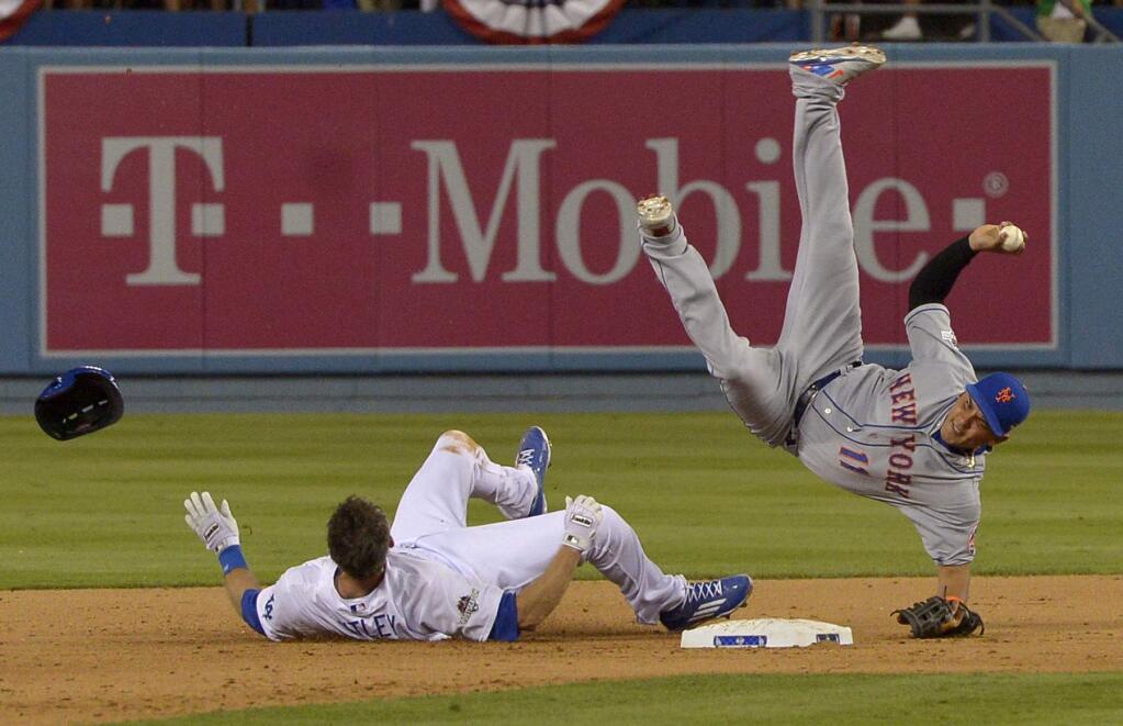 New York Mets shortstop Ruben Tejada falls after a slide by Los Angeles Dodgers' Chase Utley during the seventh inning of an NL Division Series baseball game Saturday, Oct. 10, 2015, in Los Angeles. (John McCoy/Los Angeles Daily News via AP)
