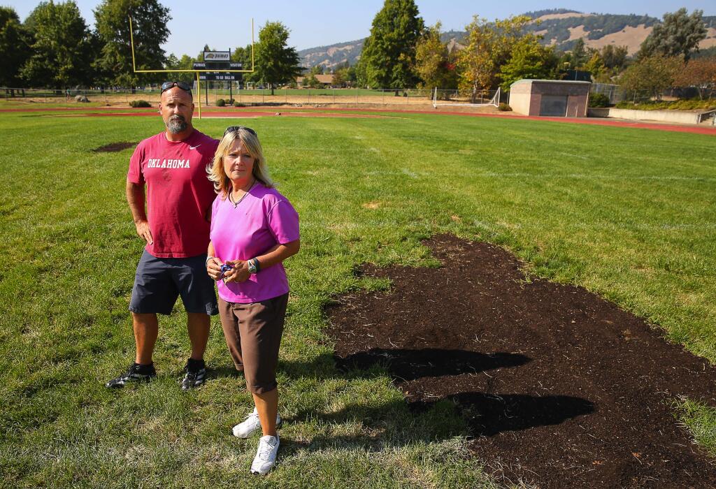 Maria Carrillo's head football coach Jay Higgins, left, and girls soccer head coach Debra LaPrath are concerned for the safety of their athletes, as well as visiting teams, because of the state of their athletic field. The field has an uneven surface, and dirt used to repair the field contains rocks, glass, and other debris.(Christopher Chung/ The Press Democrat)