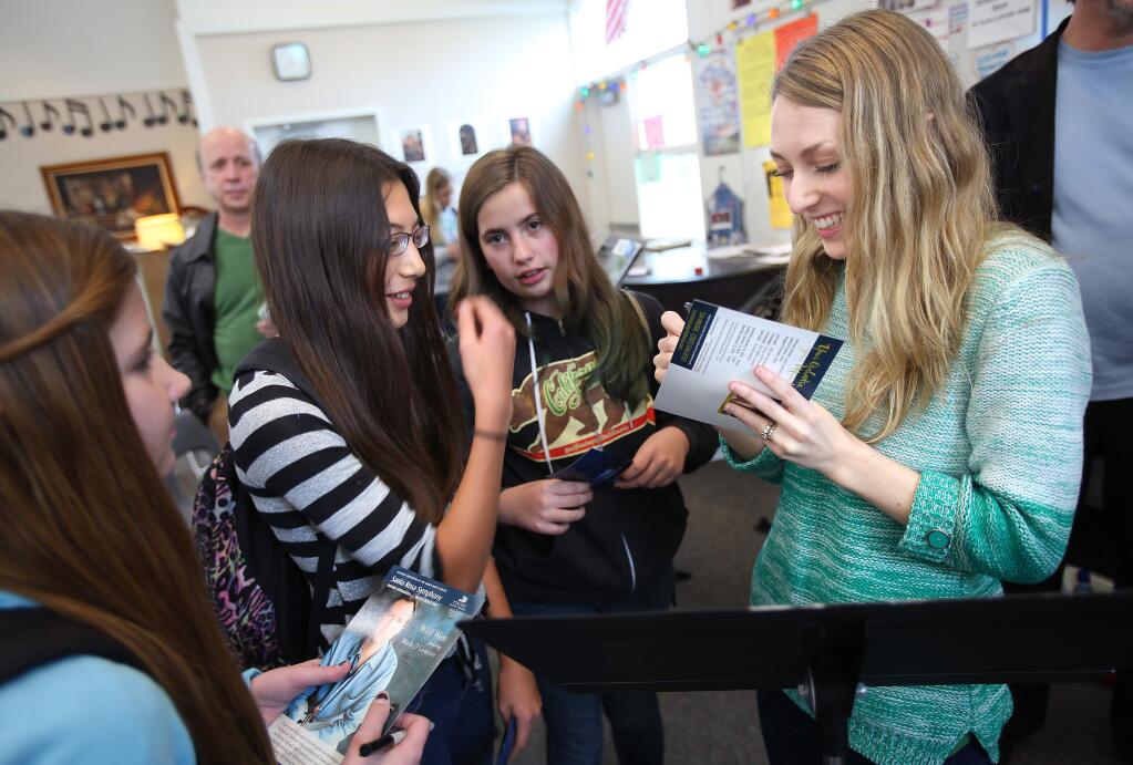 Musician Maggie O'Connor signs autographs for students Jenna Betry, Mina Burns and Haley Bates after performing with her husband, Mark O'Connor, for the Strings Orchestra at Windsor Middle School on Friday, January 9, 2015.(Christopher Chung/ The Press Democrat)