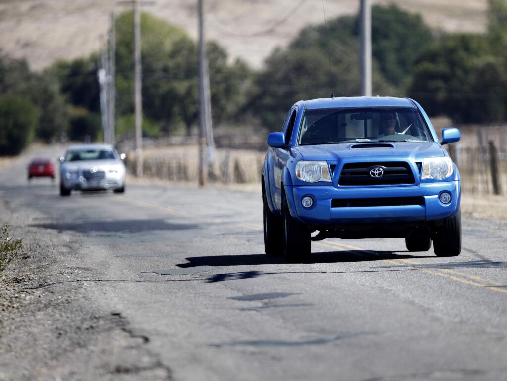 9/26/2011: B1:PC: Cars drive down the center of Lichau Rd. to avoid potholes along the sides on Tuesday, September 20, 2011, Penngrove, California. (BETH SCHLANKER/ The Press Democrat)