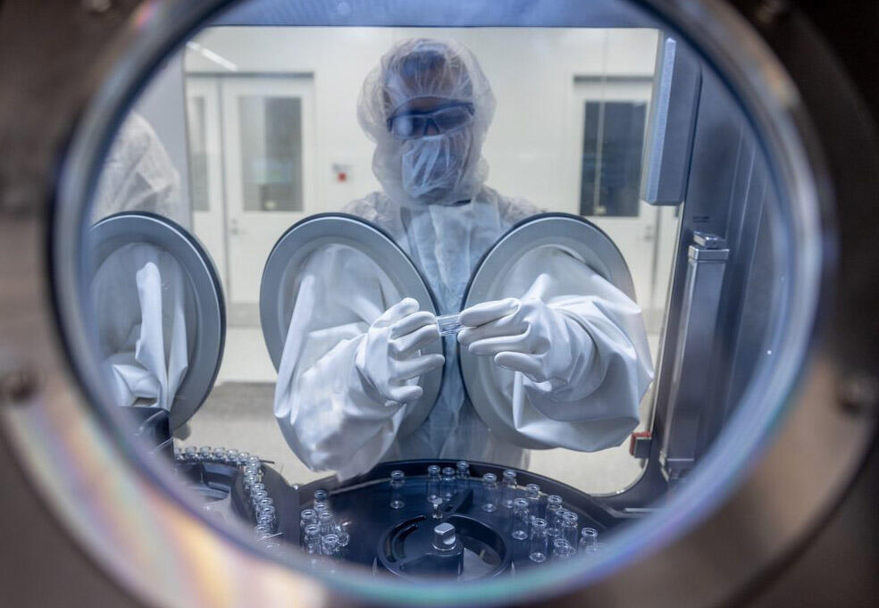 A worker handles a vial in an isolator filler at Novato-based Ultragenyx Pharmaceutical’s newest gene therapy manufacturing plant, which opened in Bedford, Massachusetts, in June 2023. (Courtesy: Ultragenyx Pharmaceutical)